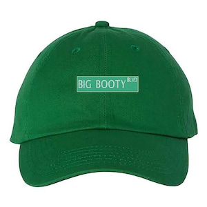 May include: A green baseball cap with the text "BIG BOOTY BLVD" in white on a white rectangle.