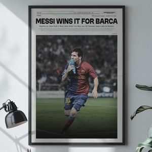 Puede incluir: Un titular de periódico en blanco y negro dice "MESSI WINS IT FOR BARCA" con una foto de Lionel Messi celebrando en un campo de fútbol. El titular está en negrita, en letra grande. La foto muestra a Messi con un uniforme de fútbol rojo y azul, sosteniendo una botella de agua azul en la boca. Corre hacia la cámara con una expresión decidida en su rostro.