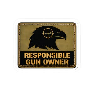 Könnte beinhalten: Rechteckiger Aufkleber mit einer schwarzen Adlerkopf-Silhouette und einem Fadenkreuz. Der Text "RESPONSIBLE GUN OWNER" steht in fetten, gelben Buchstaben auf dunklem Hintergrund mit goldenem Rand.