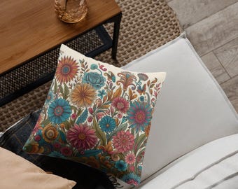 Könnte beinhalten: Ein dekoratives Kissen mit einem Blumenmuster, das eine Vielzahl von bunten Blumen zeigt, darunter rosa, blaue, gelbe und orangefarbene. Das Kissen liegt auf einem weißen Sofa.