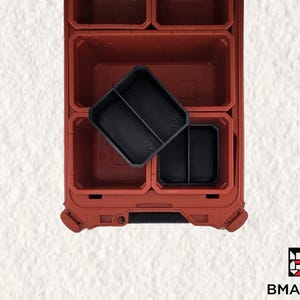 Puede incluir: Caja de herramientas de plástico roja con múltiples compartimentos. La caja de herramientas tiene un inserto de plástico negro con dos compartimentos.