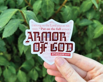 May include: A white sticker with a red and blue design that says "Armor of God" with the Bible verse "Ephesians 6:11" printed below.