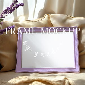 May include: A purple picture frame with a white mat and a wavy edge sits on a beige couch with a throw blanket. The frame is blank and ready for a photo or artwork. The text "FRAME MOCKUP by yaadle" is written in white on the frame.