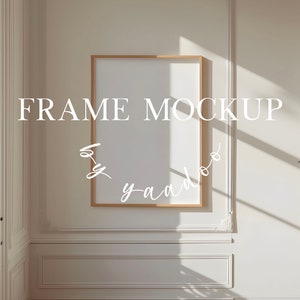 Könnte beinhalten: Ein weißer Rahmen-Mockup mit einem Holzrahmen in einem weißen Raum mit einem Fenster und einfallendem Sonnenlicht. Der Text "FRAME MOCKUP by yaado" ist in Weiß an der Wand geschrieben.