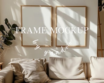 Op de afbeelding: Twee lege, licht houten fotolijsten met een witte passe-partout, hangend aan een witte muur. De lijsten hangen naast elkaar, met een bank en kussens op de voorgrond. De tekst "FRAME MOCKUP" is in wit op de muur geschreven.