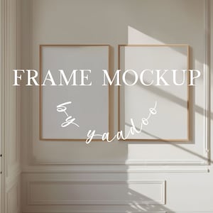 May include: Two empty picture frames with a light wood frame, hanging on a white wall with white trim. The frames are side by side and are in a room with a window and a door. The text "FRAME MOCKUP" is written in white letters on the wall.