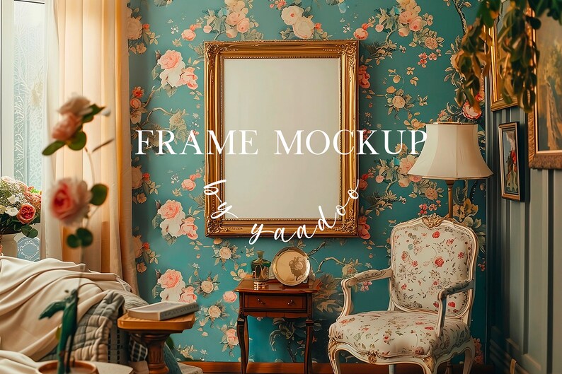 May include: A gold picture frame mockup with a white background, hanging on a wall with a floral wallpaper pattern. The frame is in a room with a chair, a side table, and a lamp.