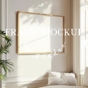 Könnte beinhalten: Ein goldfarbener Bilderrahmen-Mockup in einem weißen Raum mit einer Pflanze und einem weißen Sofa. Der Rahmen ist leer und bereit für Ihr Design.