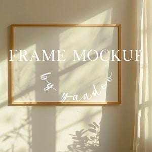 以下が含まれることがあります： 白い背景のウッドフレームのモックアップ。フレームはベージュの壁に掛けられており、背景には窓と白いカーテンがあります。フレームには「FRAME MOCKUP by yaado」というテキストが白で書かれています。