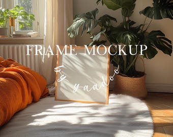 Könnte beinhalten: Ein Holzrahmen-Mockup mit weißem Hintergrund. Der Rahmen steht auf einem weißen Teppich vor einer Topfpflanze. Der Text "FRAME MOCKUP by yaado" ist in Weiß auf dem Bild geschrieben.