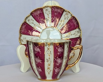 Porcelain hand-painted demitasse tea cup and articulated saucer opalescent and maroon Japan