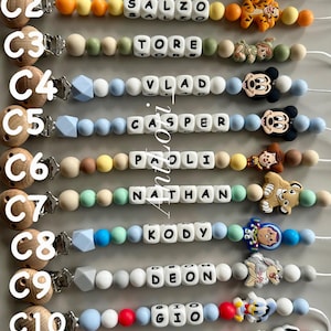 Puede incluir: Once clips para chupetes etiquetados de C1 a C11, cada uno con un clip de madera, cuentas de silicona de colores, cuentas de letras blancas que deletrean nombres como HEGAN, SALZO, TORE, VLAD, CASPER, PAOLI, NATHAN, KODY, DEON, GIO y HOLAIS, y un dije.