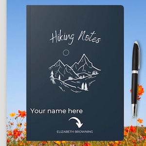 May include: A dark blue notebook with the text "Hiking Notes" in white cursive writing. A white line drawing of mountains and trees is below the text. The text "Your name here" is below the drawing with an arrow pointing down to the text "ELIZABETH BROWNING".