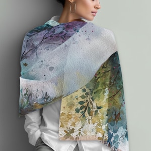 May include: A watercolor-style scarf with a nature-inspired design. The scarf features a blend of colors, including blues, greens, purples, and yellows, with a soft, flowing appearance. The design includes tree branches and leaves, creating a serene and artistic look.