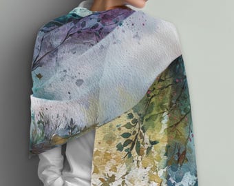 May include: A watercolor-style scarf with a nature-inspired design. The scarf features a blend of colors, including blues, greens, purples, and yellows, with a soft, flowing appearance. The design includes tree branches and leaves, creating a serene and artistic look.