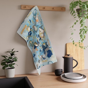 May include: A blue kitchen towel with a Japanese illustration of frogs in various poses. The towel features the text "くつわと".