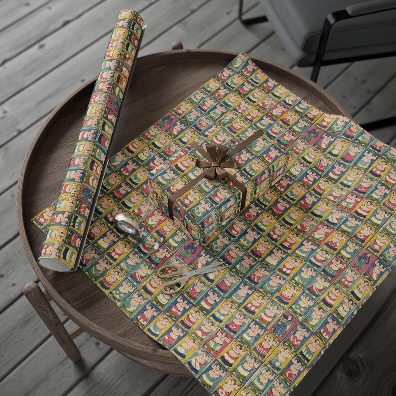 Puede incluir: Un rollo de papel de regalo con un patr&oacute;n repetitivo de figuras coloridas. El papel est&aacute; sobre una mesa de madera con una cinta marr&oacute;n y una caja de regalo envuelta en el mismo papel.