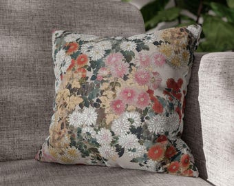 Könnte beinhalten: Ein dekoratives Kissen mit einem Blumendruck mit rosa, weißen und roten Blumen auf beigefarbenem Hintergrund.