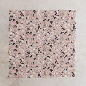 Pu&ograve; includere: Un tessuto quadrato rosa con un motivo ripetuto di illustrazioni di gatti in bianco, nero e grigio. I gatti sono raffigurati in varie pose, creando un design giocoso. Il tessuto &egrave; probabilmente destinato all'arredamento della casa o all'artigianato.