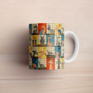 May include: White ceramic mug with a colorful pattern of hand shadow puppets. The pattern includes images of a rabbit, a bird, a cat, and a fish. The mug has a white handle.