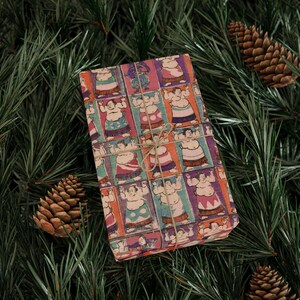 Puede incluir: Un regalo envuelto en papel de regalo colorido con un patr&oacute;n repetido de luchadores de sumo en varias poses. El papel es de color marr&oacute;n claro con un aspecto vintage.