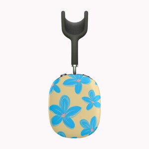 May include: A pair of wireless headphones with a floral design. The headphones have a tan base color with a pattern of blue flowers. The top portion of the headphones is black, with a curved, mesh-like design.