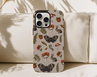 May include: A phone case with a nature-themed design. The case features a repeating pattern of butterflies, mushrooms, rabbits, and flowers in shades of brown, red, and green on a gray background. The case has a black camera module.