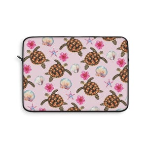 May include: Laptop sleeve with a repeating pattern of sea turtles, pink flowers, seashells, and starfish on a pale pink background. The turtles have brown shells with black spots. The sleeve has a black zip and trim.