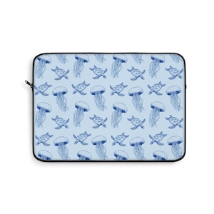 May include: A light blue laptop sleeve with a repeating pattern of blue jellyfish and sea turtles. The sleeve has a black zip and trim, providing a contrasting border to the marine life design.