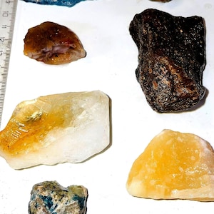 Puede incluir: Surtido de seis piedras pulidas, que incluyen un ágata azul, una piedra marrón y negra, un citrino amarillo, un citrino blanco y amarillo, una piedra verde y marrón y una calcita amarilla.