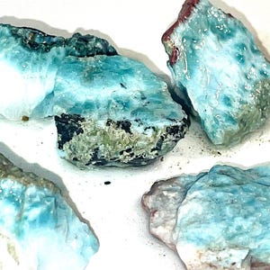 May include: Five blue, green, and white gemstone rocks with a layered, iridescent appearance. The rocks are rough and have a natural, unpolished finish.