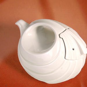 May include: A trio of ceramic mugs with a speckled, matte finish in cream, light grey, and dark grey. Each mug features a minimalist design and a rounded handle.