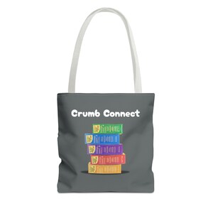 May include: A gray tote bag with white handles and the text "Crumb Connect" printed in white. A stack of colorful boxes with the text "BigCrumb" printed on them is centered on the bag.