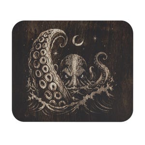Op de afbeelding: Een rechthoekige houten plaat met een lasergegraveerde illustratie van een octopus die uit oceaangolven tevoorschijn komt. Het ontwerp bevat een grote tentakel die omhoog krult, een maansikkel en kleine sterren op een donkere houtnerf.