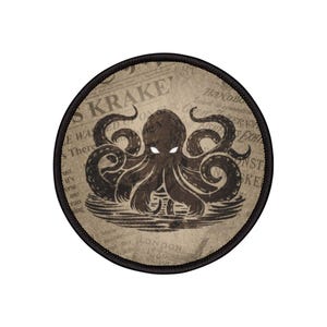 May include: A round patch featuring a brown octopus illustration with glowing white eyes, set against a vintage newspaper background. The patch has a black border and includes the text "KRAKE" and "LONDON 1885".