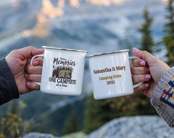 May include: Two white enamel camping mugs with black text and graphics. One mug says "Making Memories One Campsite at a time" with a vintage camper illustration. The other mug says "Samantha & Mary Camping Since 2021".
