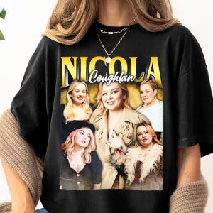 Può includere: T-shirt nero con la scritta dorata "NICOLA COUGHLAN". Il design presenta un collage di immagini di Nicola Coughlan in varie pose e outfit, creando un'estetica vintage.