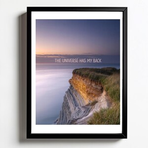 Sztuka ścienna Coastal | The Universe Has My Back Print | Plakat z motywującym cytatem | Plakat z zachodem słońca na klifie oceanicznym | Duchowy wystrój niebiański
