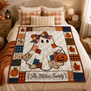 May include: A quilted throw blanket featuring a central ghost character with a plaid bow, holding a jack-o'-lantern bucket filled with candy. The border consists of patchwork squares with autumn patterns, maple leaves, and pumpkins. The text reads The Miller Family.
