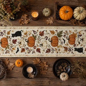 Peut inclure: Un chemin de table rectangulaire au fond crème orné d'un motif répétitif de citrouilles orange, de chats noirs, de chauves-souris sombres et de feuilles d'automne. Le design présente des vignes et des baies brunes reliant les éléments.