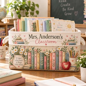 May include: A rectangular fabric storage bin with rope handles, featuring the text "Mrs. Anderson's Classroom" and "It takes a big heart to shape little minds." The design includes illustrations of books, daisies, and an apple.
