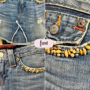 May include: Light blue denim skirt with distressed details. The skirt features decorative beading along the pockets and waistband. The front of the skirt has a split design. The True Religion Jeans logo is visible on the button.