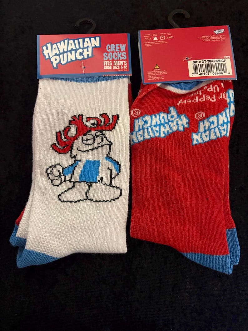 May include: Two pairs of crew socks featuring the Hawaiian Punch logo. One pair is white with a cartoon character and blue accents. The other pair is red with the Hawaiian Punch logo. Both pairs have blue cuffs and are labeled "Fits Men's Shoe Size 6-12."