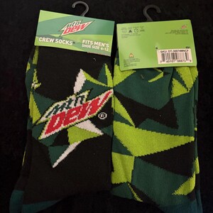 May include: Two pairs of crew socks featuring the Mountain Dew logo and geometric patterns in black, green, and white. The packaging reads "CREW SOCKS" and "FITS MEN'S SHOE SIZE 6-12".