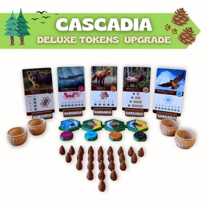 Puede incluir: Componentes del juego de mesa Cascadia Deluxe Tokens Upgrade. La imagen muestra cartas de juego con ilustraciones de animales, cuencos de madera, fichas hexagonales y fichas de pi&ntilde;as marrones. El t&iacute;tulo del juego se muestra en verde con el texto "DELUXE TOKENS UPGRADE".