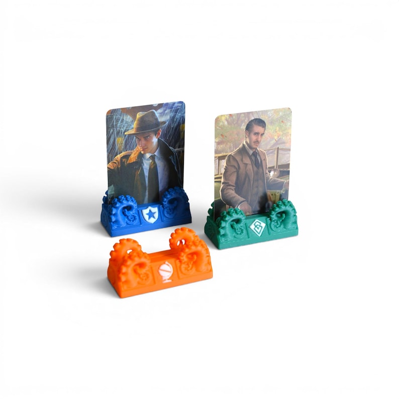 May include: Three plastic card holders featuring octopus tentacle designs in blue, green, and orange. Two holders contain rectangular character cards depicting individuals in vintage attire. Each base displays a unique white icon on the front.