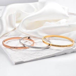 May include: Three engraved bangles in rose gold, silver, and gold. The rose gold bangle reads "Sophia ❤️ Tom." The silver bangle reads "Don't Let The Hard Days Win." The gold bangle reads "BEAUTIFUL GIRL YOU WERE MADE TO DO GREAT THINGS."