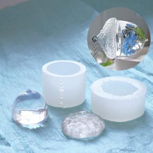 May include: Three clear silicone molds for resin casting. The molds are shaped like a dome, a cylinder, and a small acorn. The acorn mold has a small chain attached to the top.