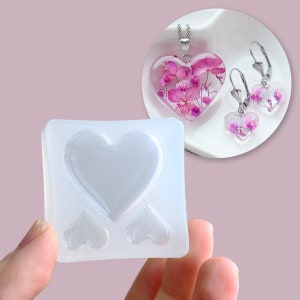 May include: A clear silicone mould with three heart-shaped cavities. The mould is designed for making resin jewellery, such as pendants and earrings.