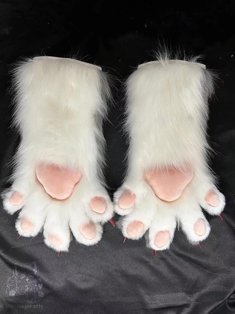 May include: A pair of white furry paw gloves with pink paw pads and pink claws. The gloves are designed to resemble animal paws, with a fluffy texture and detailed paw pads.